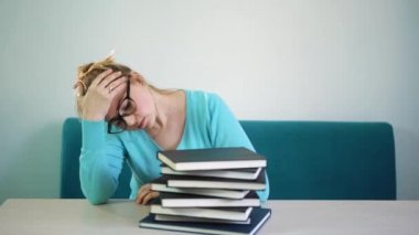 Kütüphanede kitap üstünde uyumak gözlük ile yorgun öğrenci kız