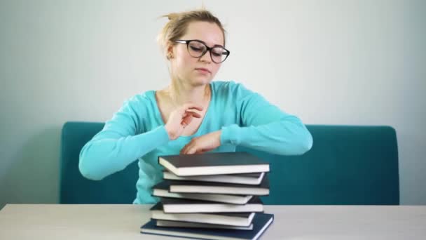 Tired student girl with glasses sleeping on the books in the library — Stock Video