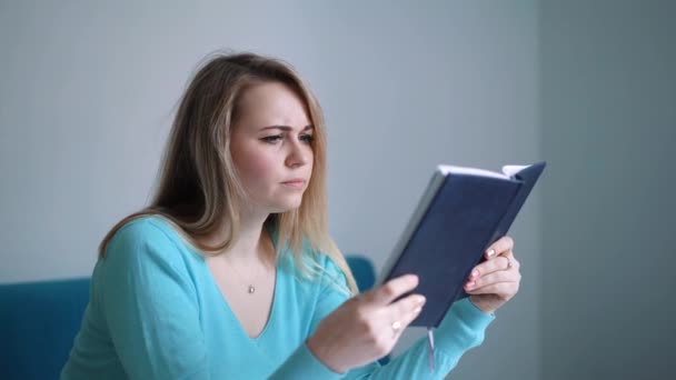 Studentin studiert und liest in einer Bibliothek, hat aber Schwierigkeiten, den Stoff zu verstehen — Stockvideo