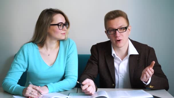 Homem e menina estudantes sentados à mesa, responder a perguntas . — Vídeo de Stock