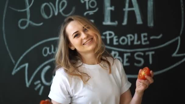 Νεαρό κορίτσι έχει τη διασκέδαση με τις ντομάτες στην κουζίνα στο σπίτι — Αρχείο Βίντεο