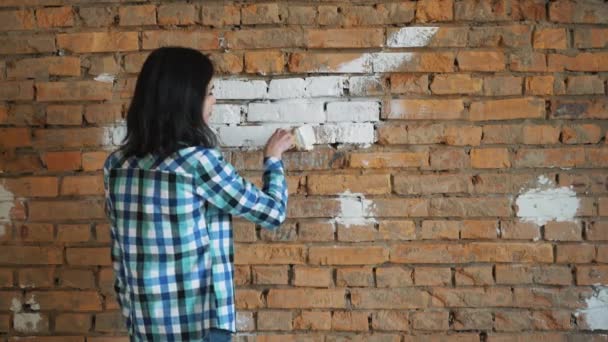 La femme peint la brique rouge à la maison dans la couleur blanche — Video