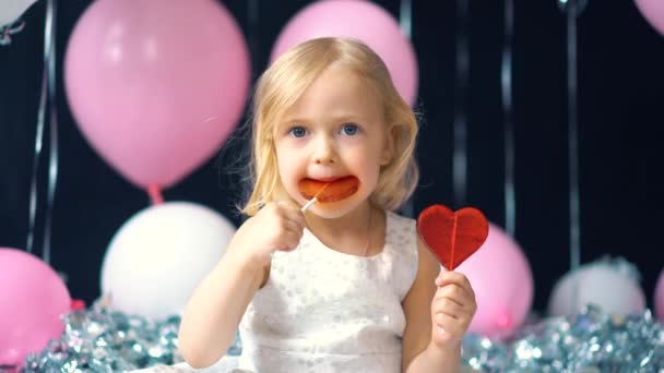 Маленькая девочка на каникулах ест конфеты — стоковое видео