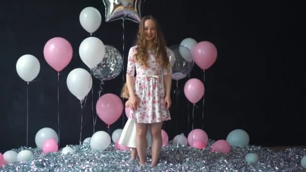 Retrato de uma jovem mãe e filha se divertindo e posando com balões de hélio coloridos — Vídeo de Stock