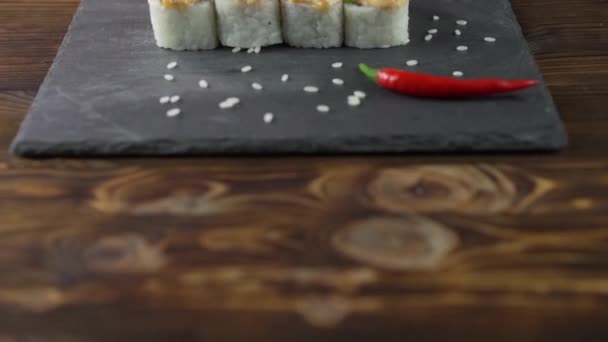 Rolo de sushi posto na mesa. Vários pratos japoneses são servidos no restaurante. Conjunto com salmão, atum, legumes, peixe voador ROE e caviar close-up . — Vídeo de Stock