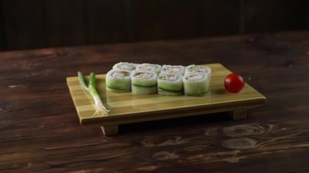 Sushi rullen dukas på bordet. Olika japanska rätter serveras på restaurangen. Set med lax, tonfisk, grönsaker, flygfisk Roe och kaviar närbild. — Stockvideo