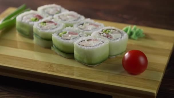 Sushi gulung diatur di atas meja. Berbagai hidangan Jepang disajikan di restoran tersebut. Diatur dengan salmon, tuna, sayuran, ikan terbang ROE dan caviar close-up . — Stok Video