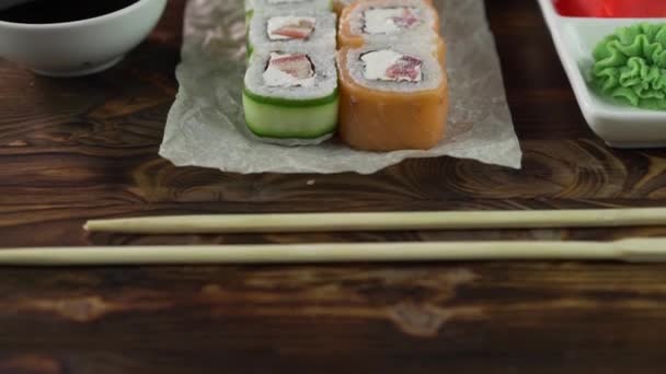 Sushi rolka na stole. V restauraci se podávají různá japonská jídla. Set s lososem, tuňákem, zeleninou, létající rybou Roe a kaviárem zblízka. — Stock video