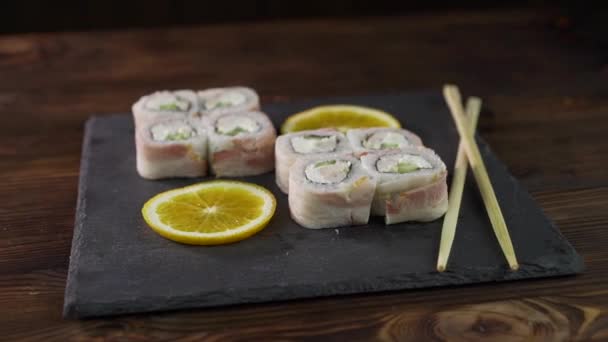 Sushi-Brötchen auf dem Tisch. Im Restaurant werden verschiedene japanische Gerichte serviert. Set mit Lachs, Thunfisch, Gemüse, fliegendem Fischrogen und Kaviar in Nahaufnahme. — Stockvideo