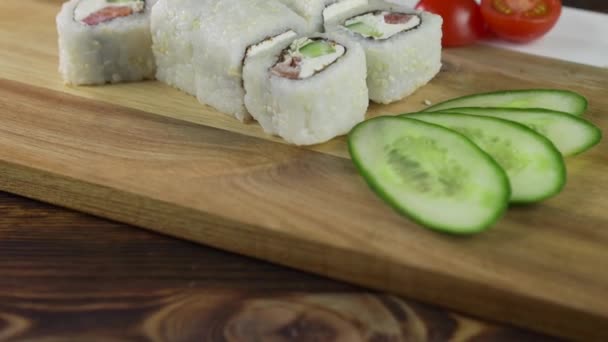Rotolo di sushi apparecchiato sul tavolo. Il ristorante propone vari piatti giapponesi. Set con salmone, tonno, verdure, pesce volante ROE e caviale primo piano . — Video Stock