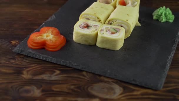 Rolo de sushi posto na mesa. Vários pratos japoneses são servidos no restaurante. Conjunto com salmão, atum, legumes, peixe voador ROE e caviar close-up . — Vídeo de Stock