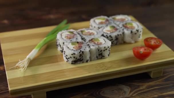 Sushi-Brötchen auf dem Tisch. Im Restaurant werden verschiedene japanische Gerichte serviert. Set mit Lachs, Thunfisch, Gemüse, fliegendem Fischrogen und Kaviar in Nahaufnahme. — Stockvideo