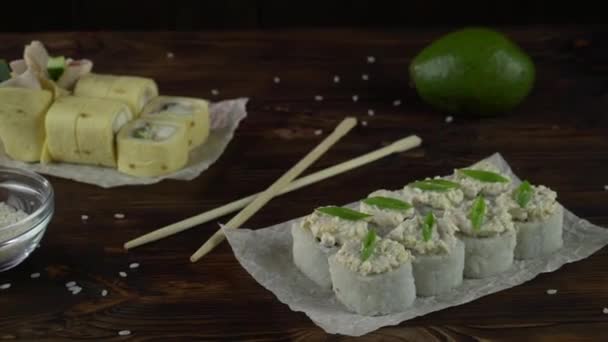 Sushi rolset op tafel. In het restaurant worden verschillende Japanse gerechten geserveerd. Set met zalm, tonijn, groenten, vliegende vis Roe en kaviaar close-up. — Stockvideo