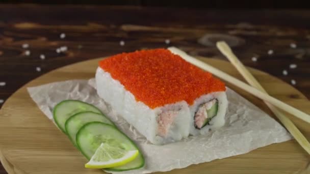 Rolka sushi na stole. W restauracji serwowane są różne dania kuchni japońskiej. Zestaw z łososiem, tuńczykiem, warzywami, rybą latającą Roe i kawiorem zbliżenie. — Wideo stockowe