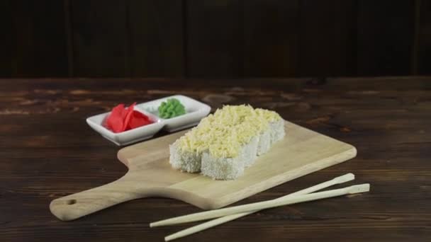 Sushi rullen dukas på bordet. Olika japanska rätter serveras på restaurangen. Set med lax, tonfisk, grönsaker, flygfisk Roe och kaviar närbild. — Stockvideo