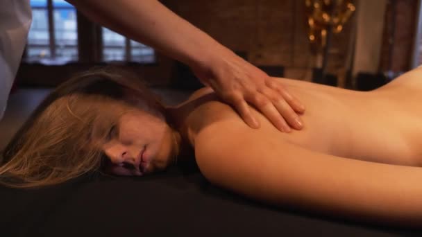 Zbliżenie masażysta ręce robi spin masaż. Dziewczyna leżąca na stole masażystki czerpie przyjemność z masażu. — Wideo stockowe