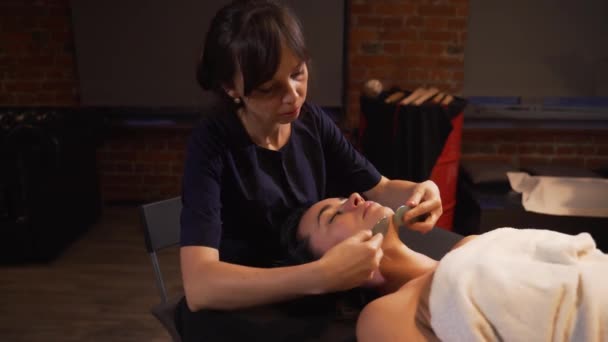 Spa mujer masaje facial. Masaje facial en salón de spa de belleza. Mujer disfrutando de masajes faciales relajantes en el centro de spa de cosmetología. Cuidado corporal, cuidado de la piel, bienestar, tratamiento de belleza . — Vídeo de stock