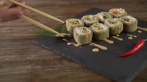 Сервировка суши-роллов на столе . — стоковое видео