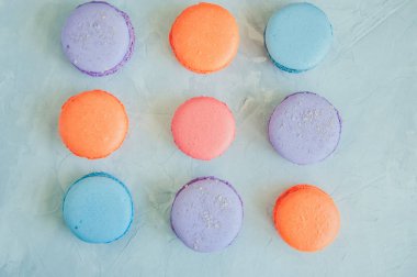 Beyaz taş zemin üzerine renkli macarons. 