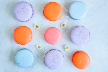 Beyaz taş zemin üzerine renkli macarons. 