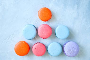 Beyaz taş zemin üzerine renkli macarons. 