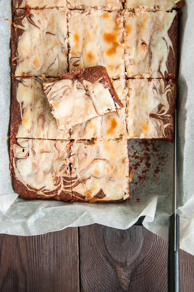 Brownie cheesecake rutor i en ugnsfast form med bakplåtspapper — Stockfoto