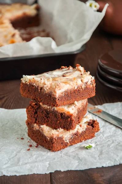 Stack av brownie cheesecake rutor på ett bakplåtspapper på en wo — Stockfoto