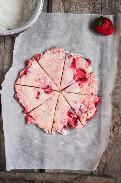 Pâte à scones de fraises coupée en segments sur un papier sulfurisé — Photo