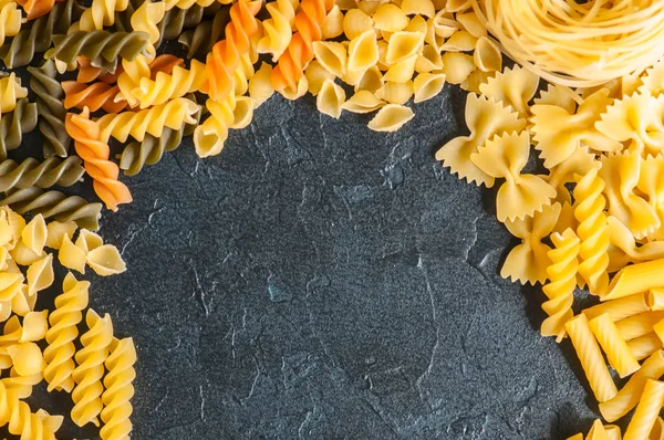 Mängd olika typer av italiensk pasta bakgrund. Uppsättning av rå pasta o — Stockfoto