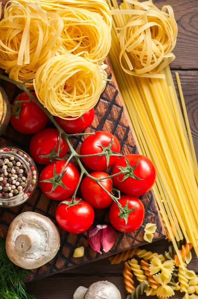 Surtido de tipos y formas crudas de pasta italiana y madera b — Foto de Stock