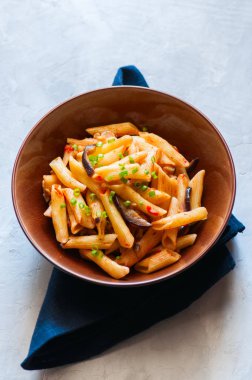 Egplants, domates ve bir beyaz üzerine yeşil soğan ile Penne makarna 