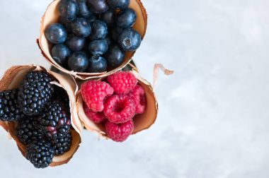 Berry ahududu kırmızı kuş üzümü ve yaban mersini bir ahşap Çantalar.
