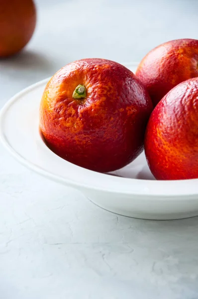 Свежий спелый цельный и ломтики апельсинов крови в тарелке на whi — стоковое фото