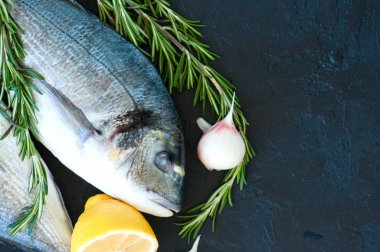 Biberiye, sarımsak ve limon bir siyah taze çiğ dorado balık