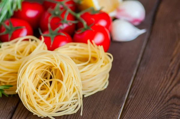 Ingredientes crudos para la cena de estilo italiano. Pastas, tomates cherry — Foto de Stock