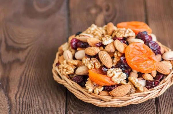 Mix of nuts and dry fruits in a wooden plate. Assortment of waln