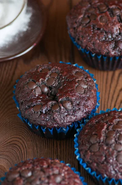 Freshly baked double chocolate muffins on a wooden background wi — Stock Photo, Image