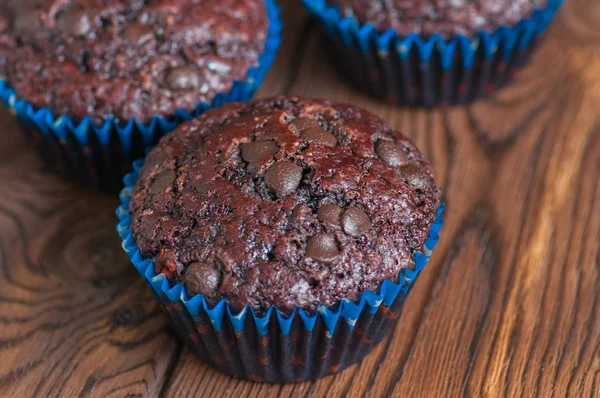 Freshly baked double chocolate muffins on a wooden background wi — Stock Photo, Image