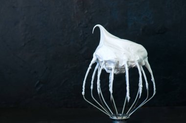 Çırpılmış yumurta akı - dövülmüş İtalyan merengue üzerinde siyah bir çırpma teli