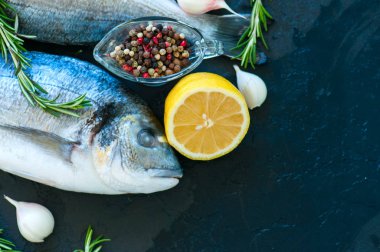Taze çiğ Dorado yakın balık, biberiye bitki sarımsak biber bir