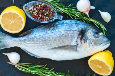 Taze çiğ Dorado yakın balık, biberiye bitki sarımsak biber bir