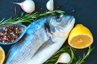 Taze çiğ Dorado yakın balık, biberiye bitki sarımsak biber bir