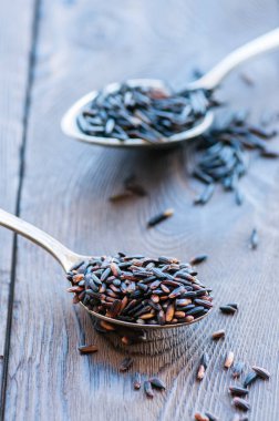 Kahverengi pirinç bir ahşap zemin üzerine bir kaşık. Tonda.