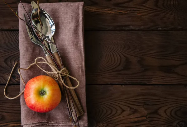 Tree branches apple cutlery on a linen sackcloth on a wooden background. — Stock Photo, Image