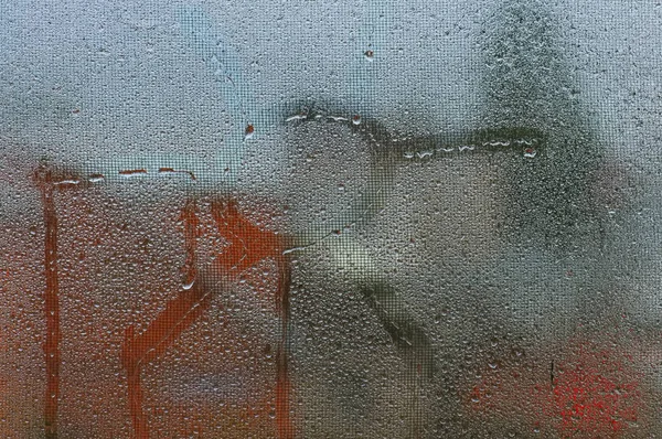 Okno z wodą kropla, napis symbol słońce na szkle — Zdjęcie stockowe