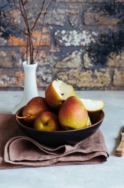Olgun armut beyaz taş zemin üzerine bir tabak içinde. Tonda. 