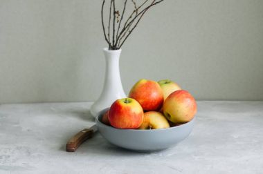 Beyaz zemin üzerinde bir kasede olgun elma. Sonbahar ruh kavramı