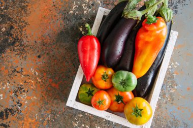 Sebzeli paslı bir arka plan üzerinde beyaz kutu. Patlıcan, bel