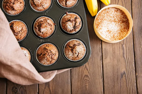 Hemmagjord banan choklad muffins beströs med socker i en baki — Stockfoto