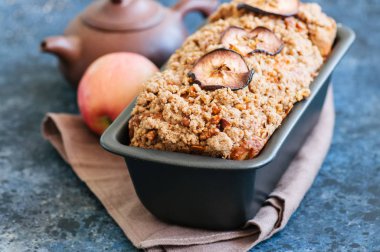 Apple kırıntı ekmek pişirme form üzerinde mavi bir taş backgr servis